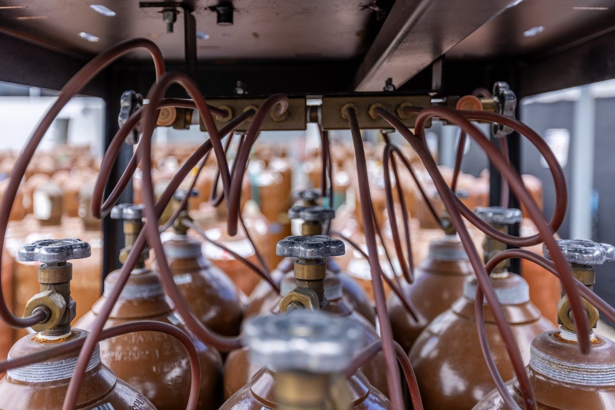 WSM helium gas cylinders connected to fill manifold — compressed helium cylinder warehouse and distribution facility in Miami